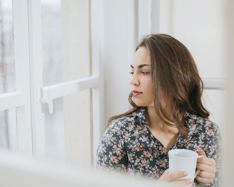 Woman looking out the window in need of ifs therapy for trauma