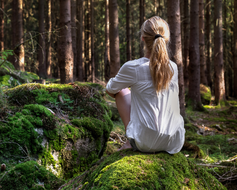 Woman sitting in the woods in need of therapy for depression in Ohio